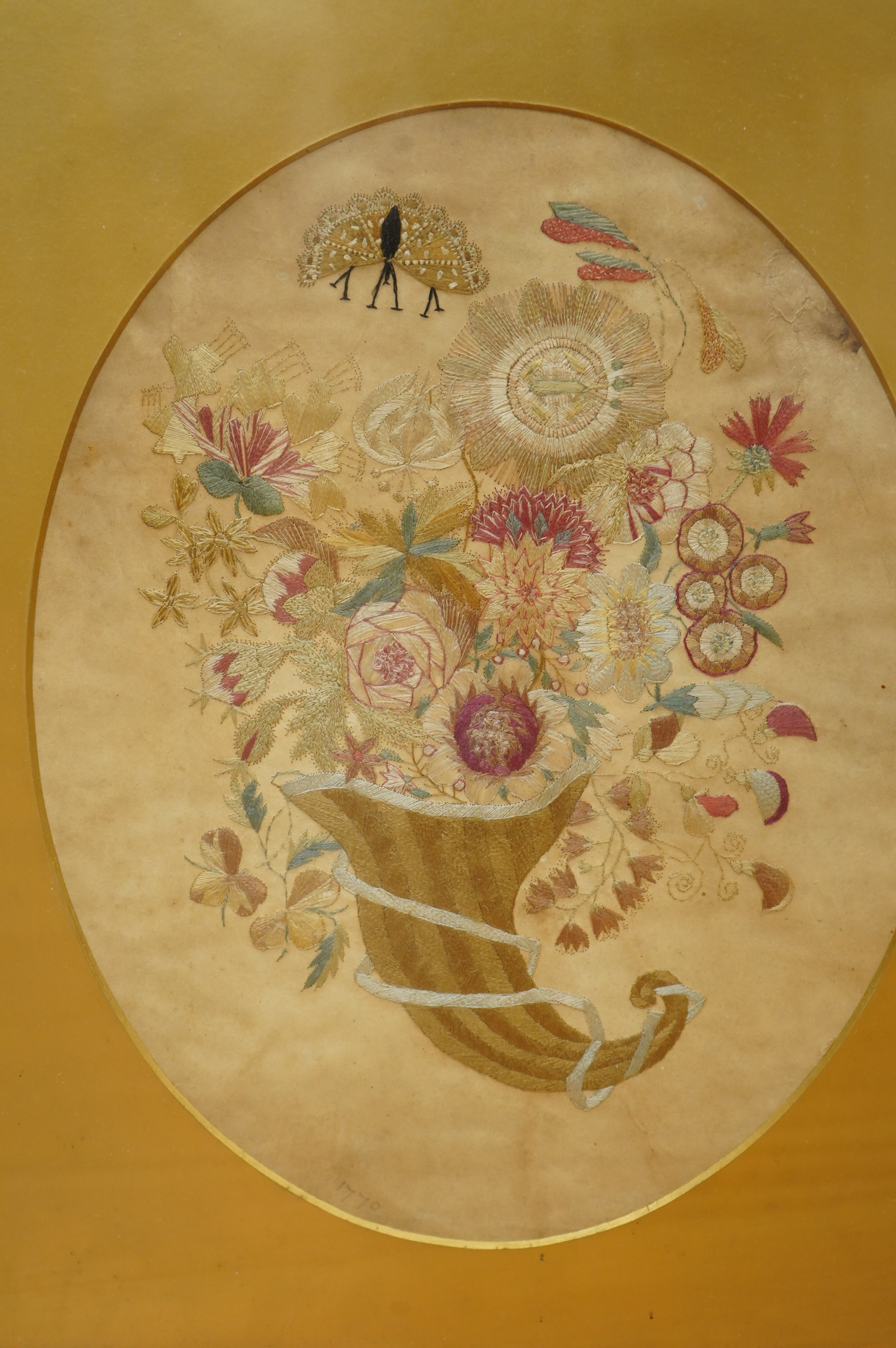 A late 18th century polychrome floral silk work embroidery of a cornucopia of flowers and a butterfly above, dated 1770, together with an early 19th century embroidery of a spray of roses surrounded by a floral border, w